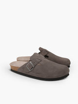 Zueco Genuins Riva  de piel serraje color gris con planta anatómica de caucho corcho y hebilla ajustable metálica para hombre, vista lateral doble.
