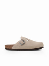 Zueco Genuins Riva  de piel serraje color taupe con planta anatómica de caucho corcho y hebilla ajustable metálica visto desde el lateral con fondo blanco.